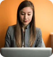 Woman smiling while looking in laptop and checking her website SERP rank in ApexTraffic